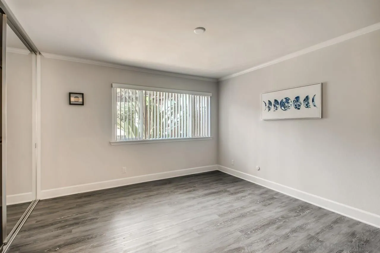 8524 Via Mallorca, Unit E La Jolla, CA 92037 - Photo 9 of 14 an empty room with wooden floor and windows