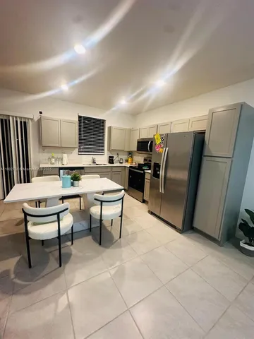 a living room with furniture a flat screen tv and a table