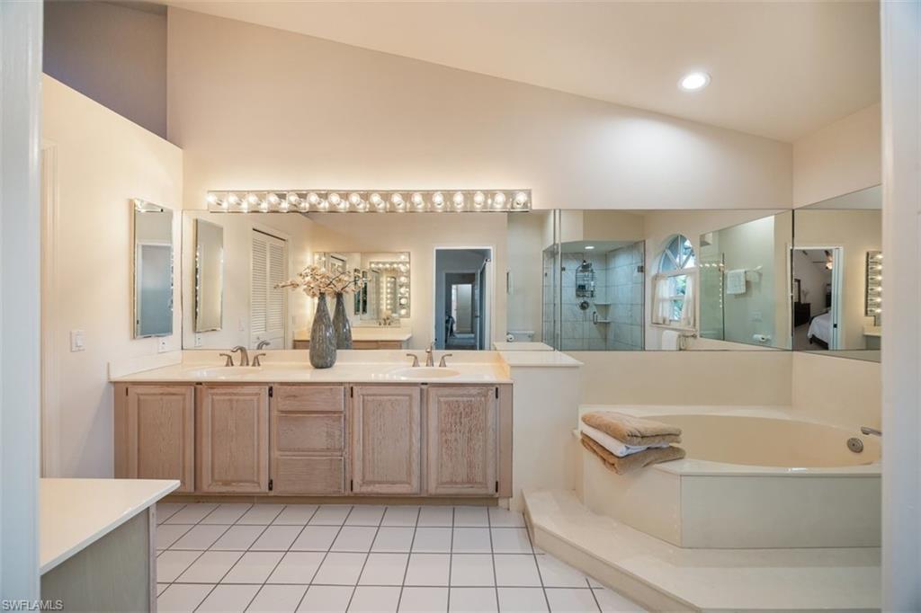 164 Via Perignon, Unit 84 Naples, FL 34119 - Photo 20 of 34 a bathroom with a tub a sink and a mirror