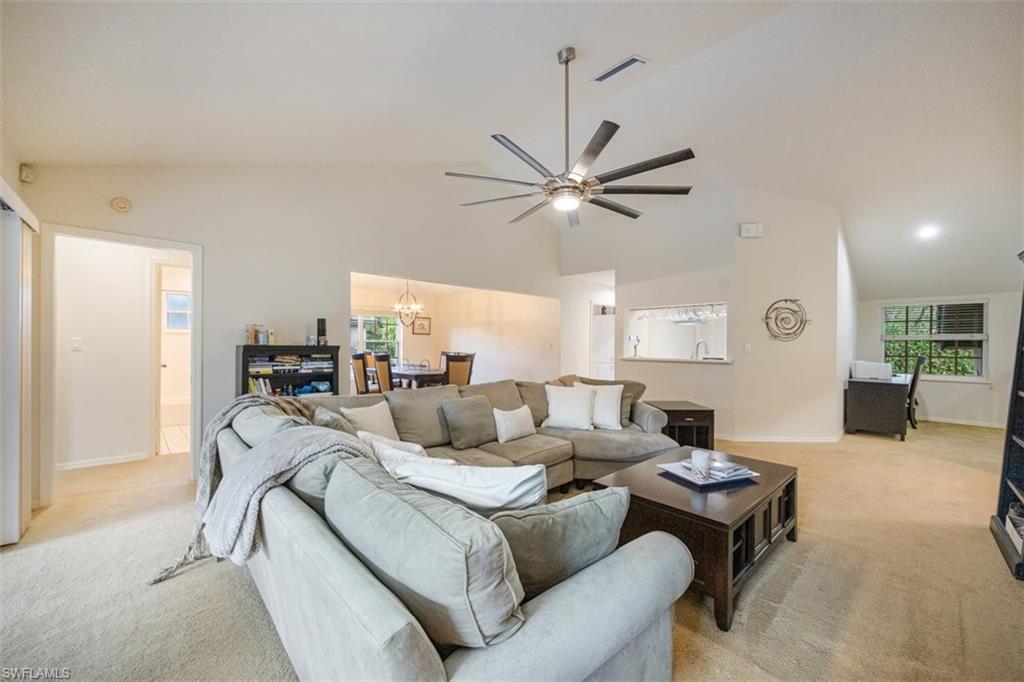 164 Via Perignon, Unit 84 Naples, FL 34119 - Photo 10 of 34 a living room with furniture a large window and a chandelier