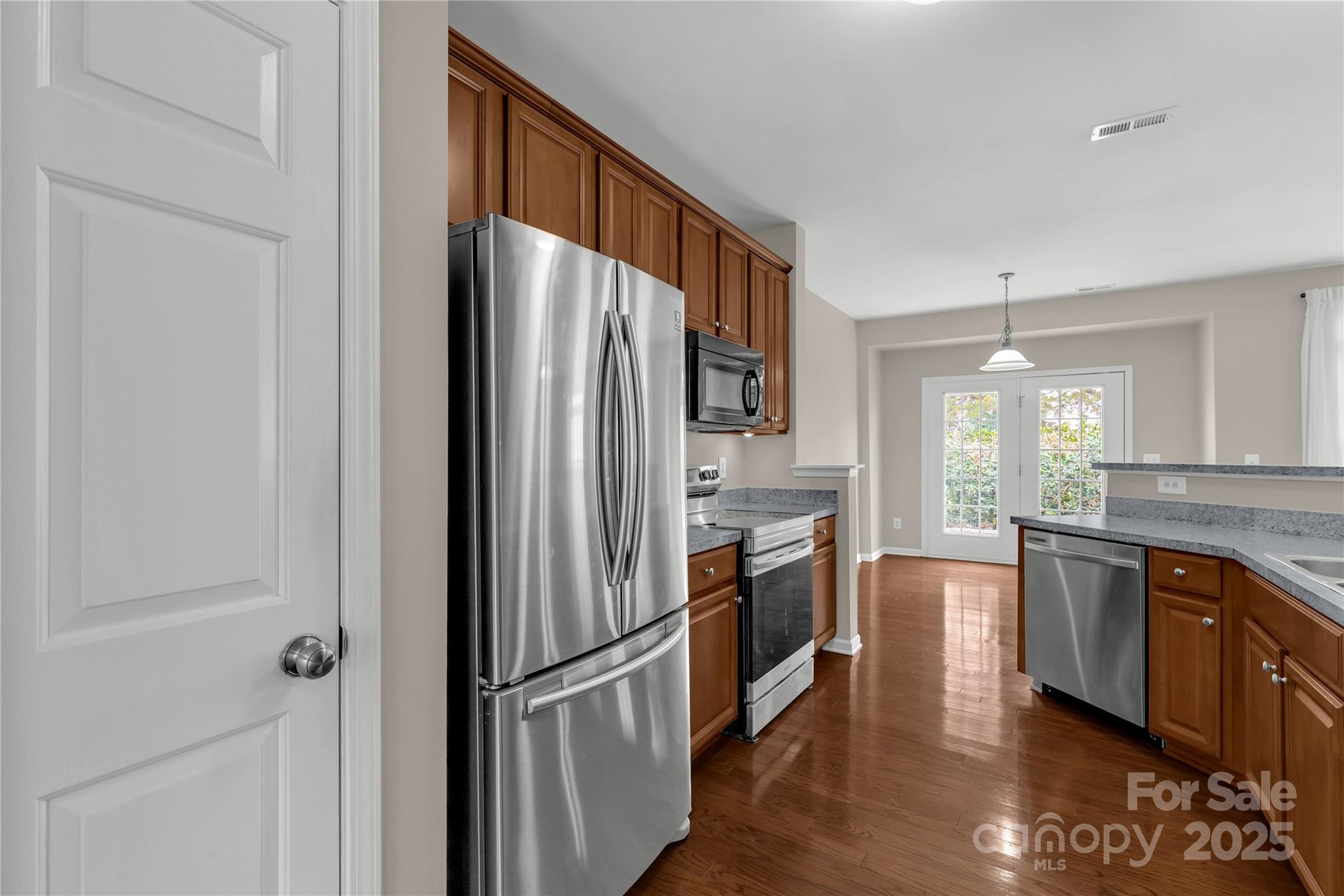 187 Snead Road Fort Mill, SC 29715 - Photo 8 of 32 a kitchen with stainless steel appliances granite countertop a refrigerator a stove and a sink with wooden floor