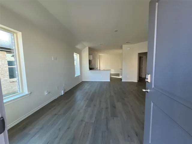 a view of a big room with wooden floor and windows
