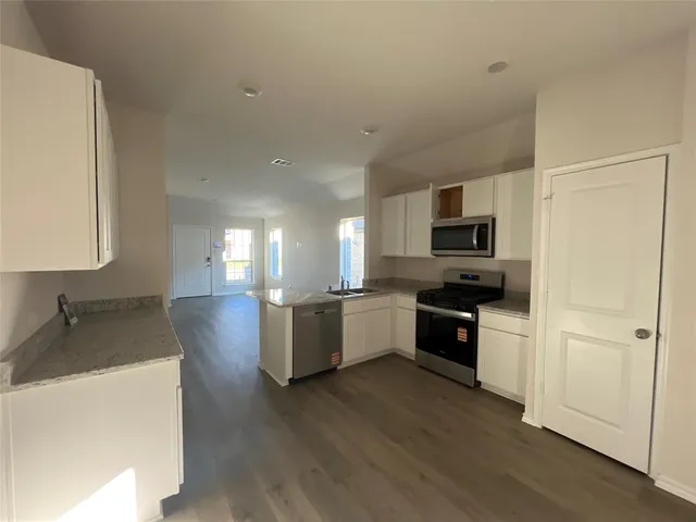 a kitchen with sink a microwave a refrigerator and cabinets