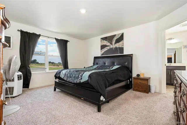 a bedroom with a bed and large window