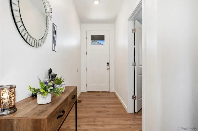 a view of a hallway with wooden floor and a mirror