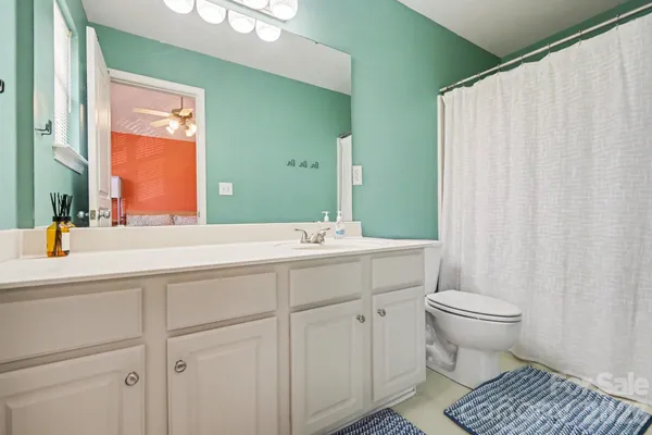 a bathroom with a sink a toilet and a mirror
