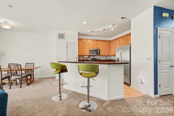 a kitchen with kitchen island granite countertop a counter top space appliances and a chandelier