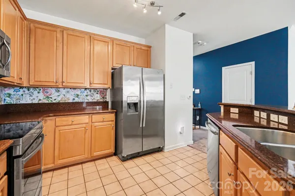 a kitchen with stainless steel appliances granite countertop a refrigerator and a sink