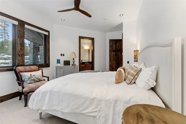 a bedroom with a bed and large windows