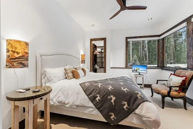 a bedroom with a bed and large windows