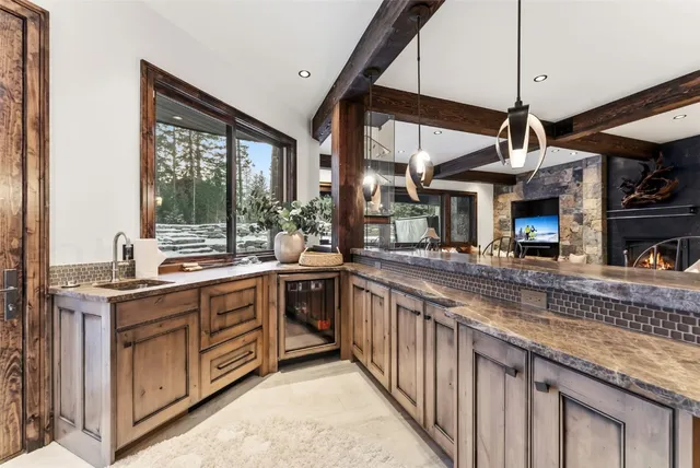 a kitchen with stainless steel appliances granite countertop a sink a stove and a wooden floors