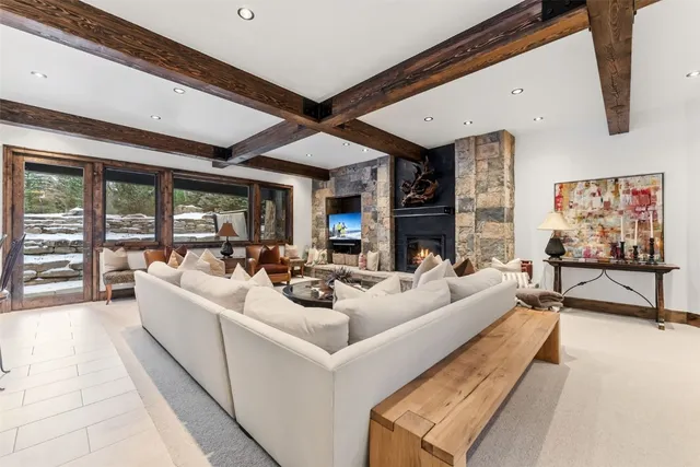 a kitchen with stainless steel appliances kitchen island granite countertop a refrigerator a stove a dining table and chairs with wooden floor