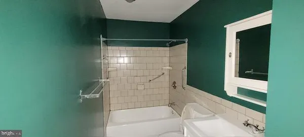 a bathroom with a sink and mirror with toilet