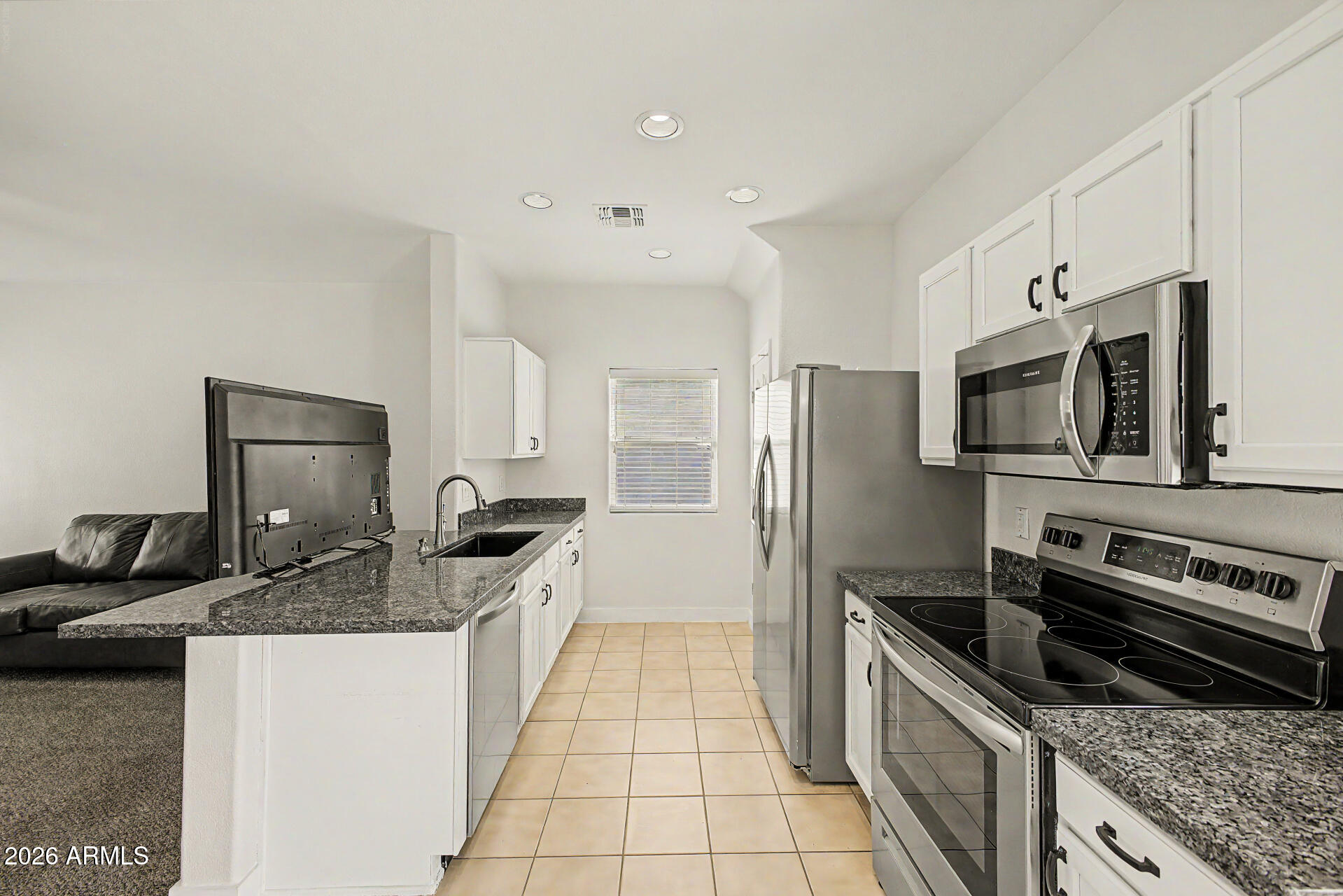 13261 West Redfield Road Surprise, AZ 85379 - Photo 8 of 36 a kitchen with granite countertop a sink and stainless steel appliances