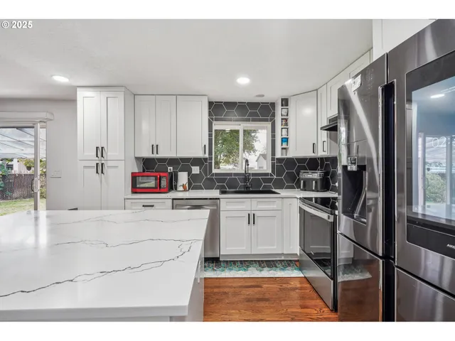 a kitchen with stainless steel appliances granite countertop a refrigerator sink and stove