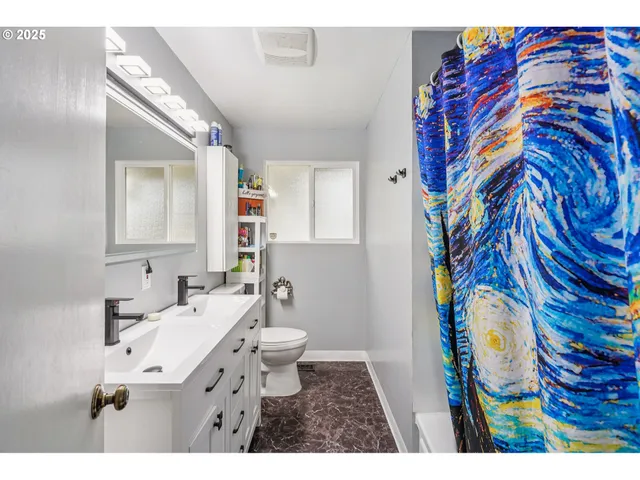 a bathroom with a sink mirror vanity and toilet