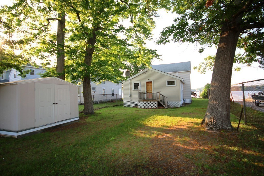1 Bisson Lane Merrimac, MA 01860 - Photo 29 of 30 a view of a white house next to a yard with a large tree