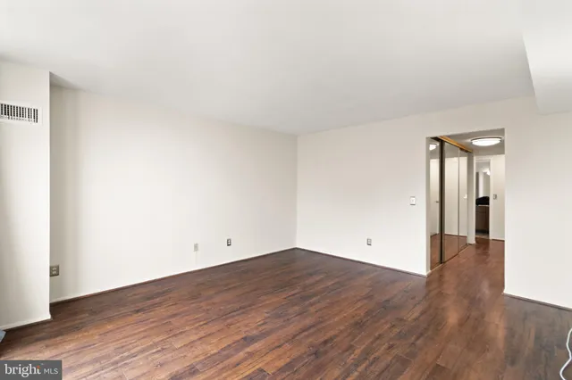 a view of an empty room with wooden floor