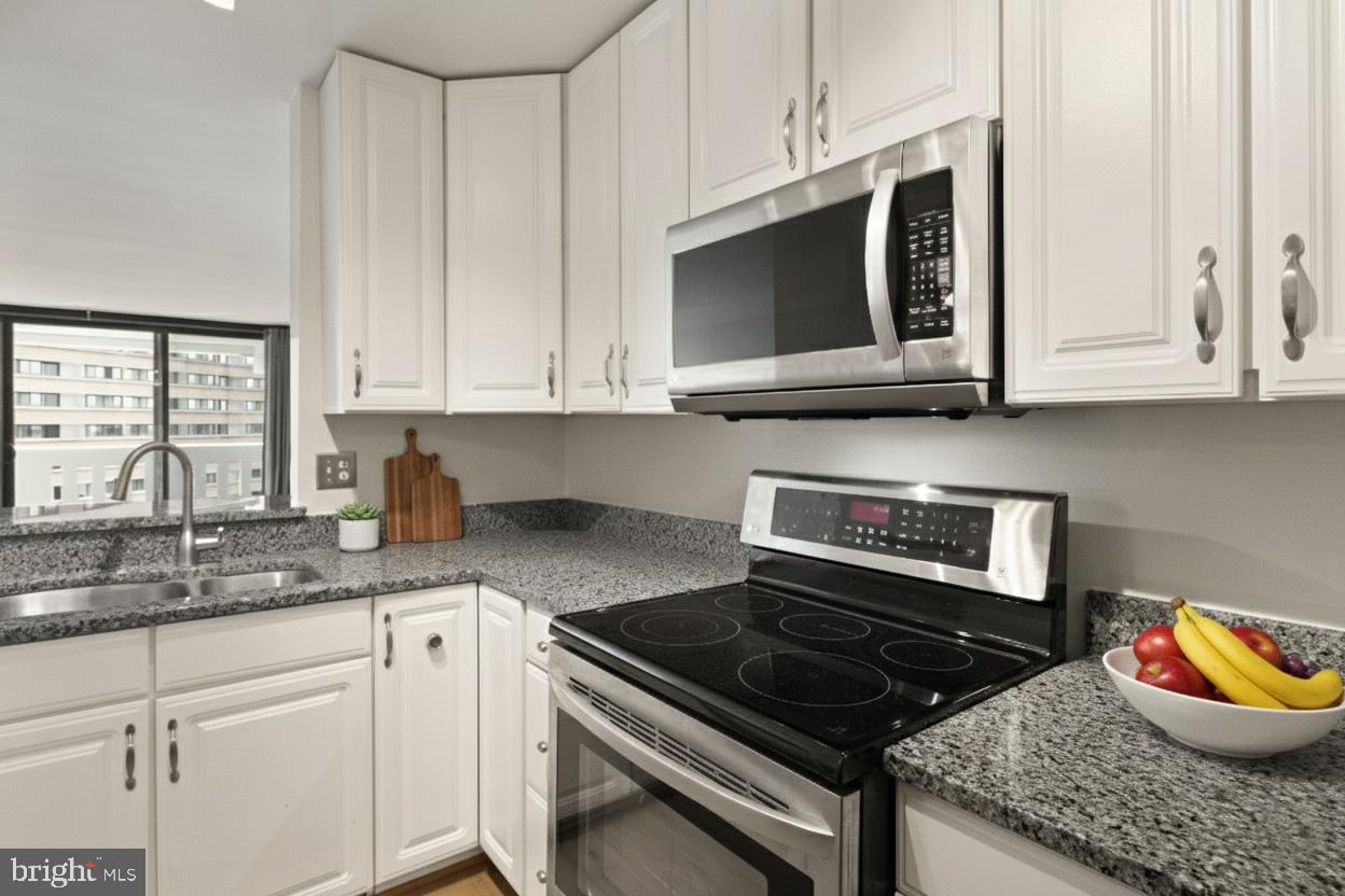 6101 Edsall Road, Unit 1209 Alexandria, VA 22304 - Photo 10 of 35 a kitchen with stainless steel appliances granite countertop a stove a microwave and cabinets