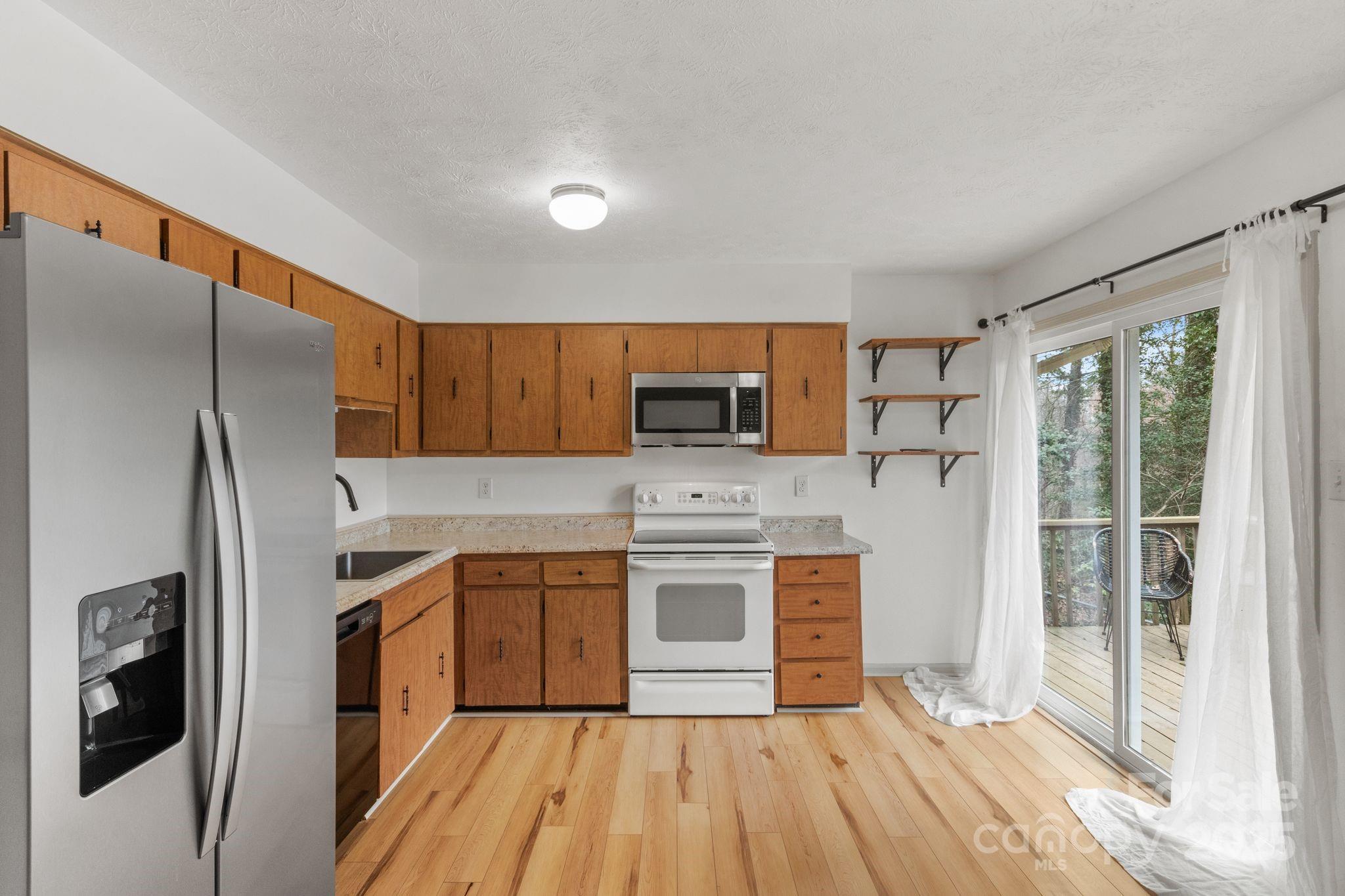 14 South Ridge Place Arden, NC 28704 - Photo 12 of 32 a kitchen with stainless steel appliances a stove sink and refrigerator