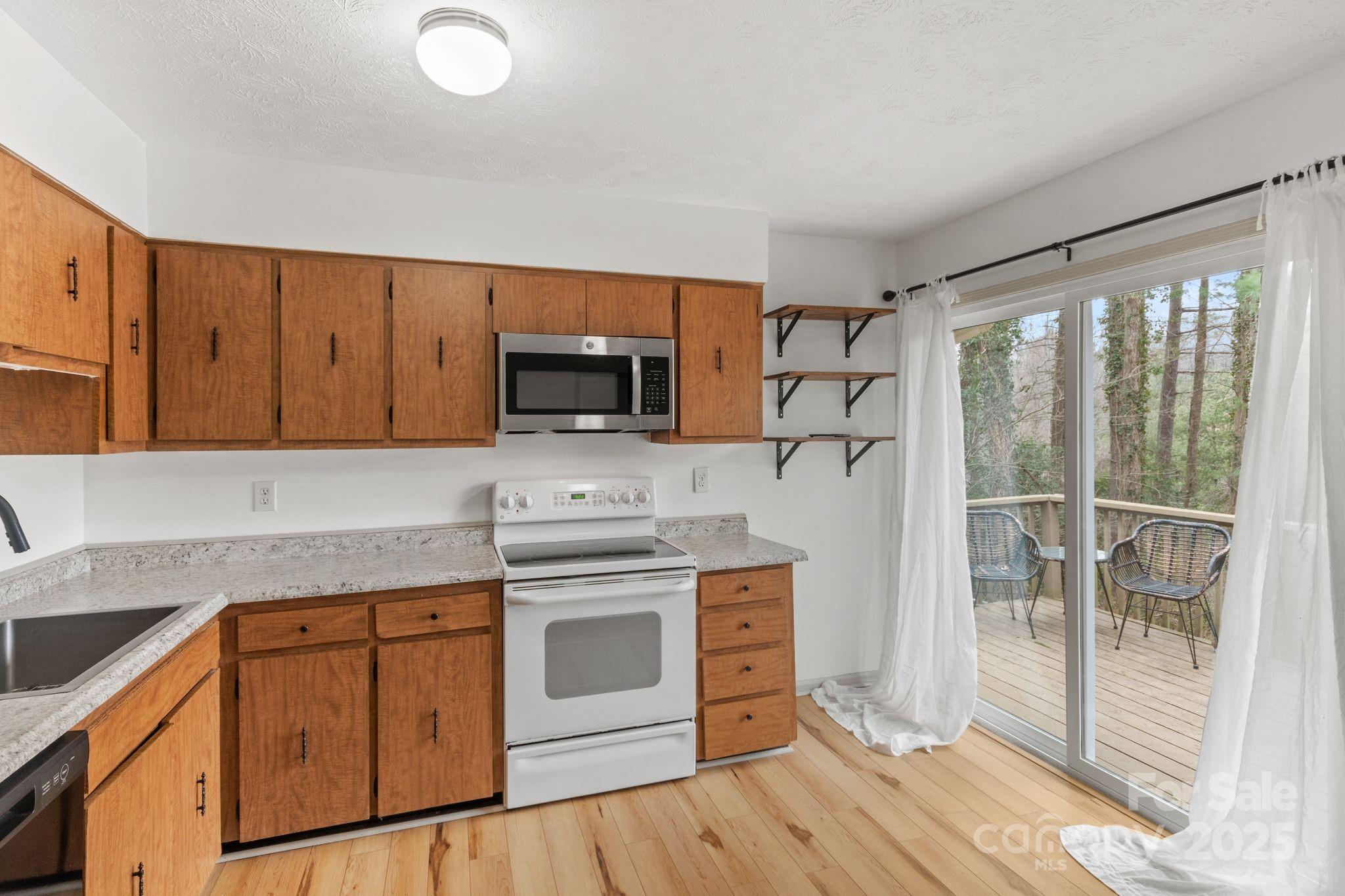 14 South Ridge Place Arden, NC 28704 - Photo 8 of 32 a kitchen with stainless steel appliances granite countertop a stove a sink and a microwave