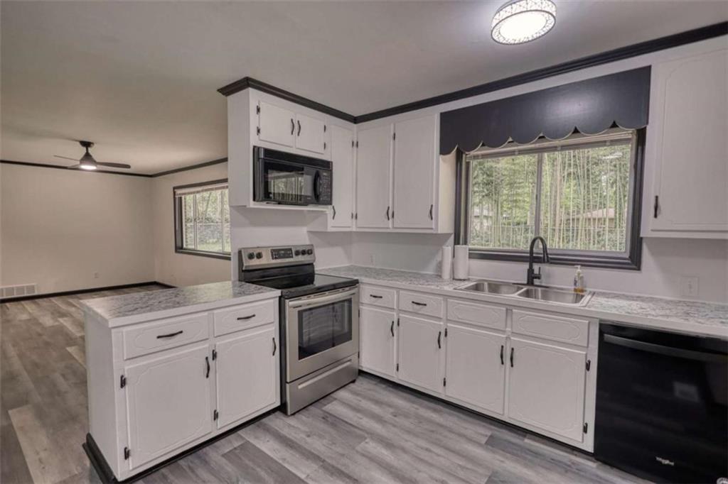 555 Joy Street Jackson, GA 30233 - Photo 23 of 56 a kitchen with a sink stove and microwave
