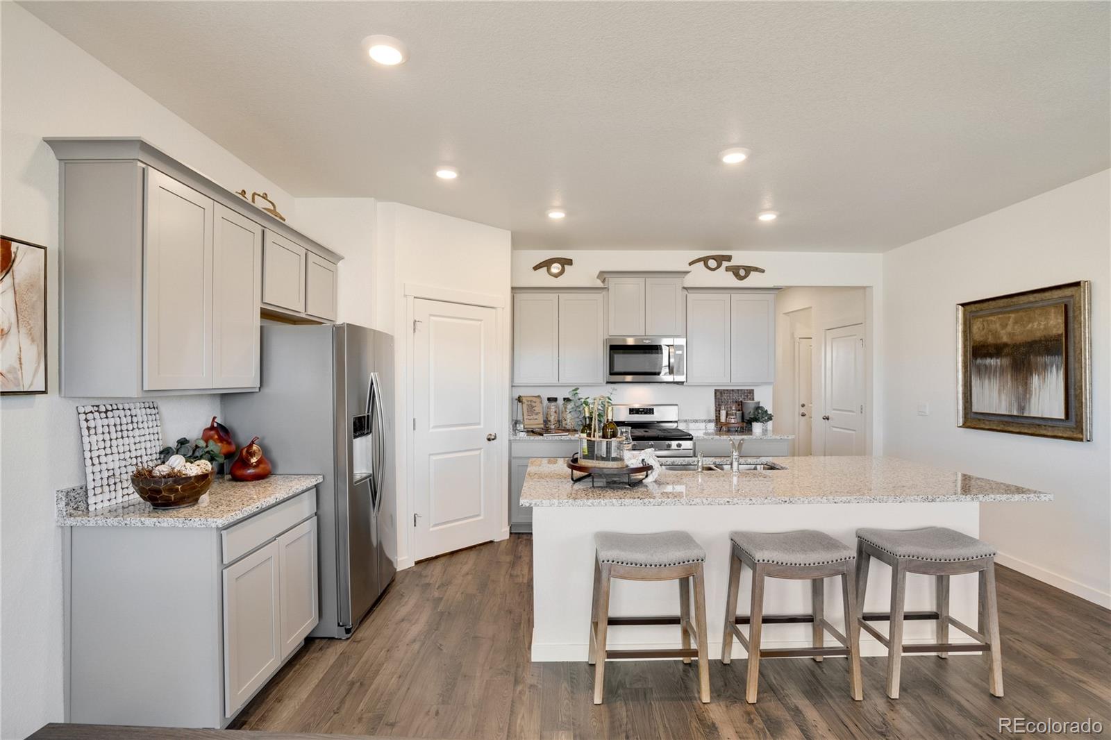 622 Sawyers Pond Drive Severance, CO 80550 - Photo 11 of 25 a kitchen with white cabinets and chairs