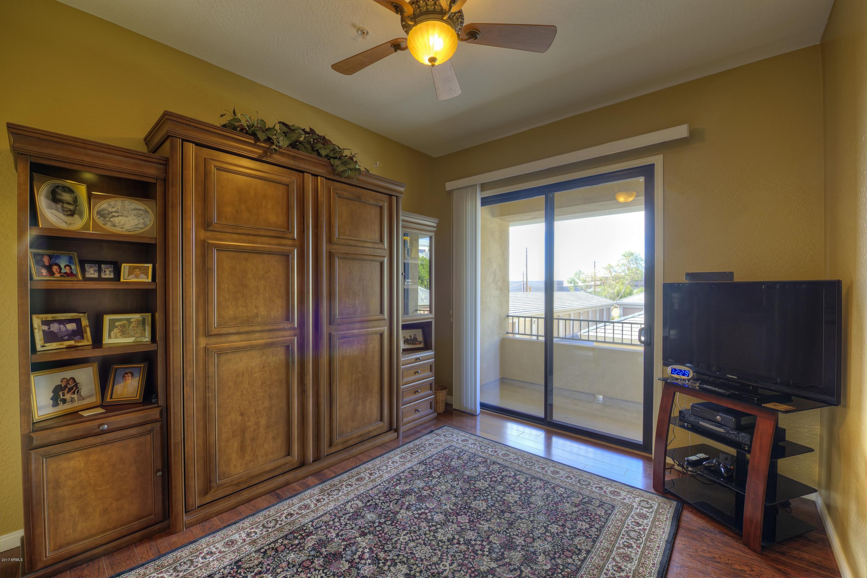 4488 East Thomas Road, Unit 2046 Phoenix, AZ 85018 - Photo 11 of 18 a living room with closet and a flat screen tv