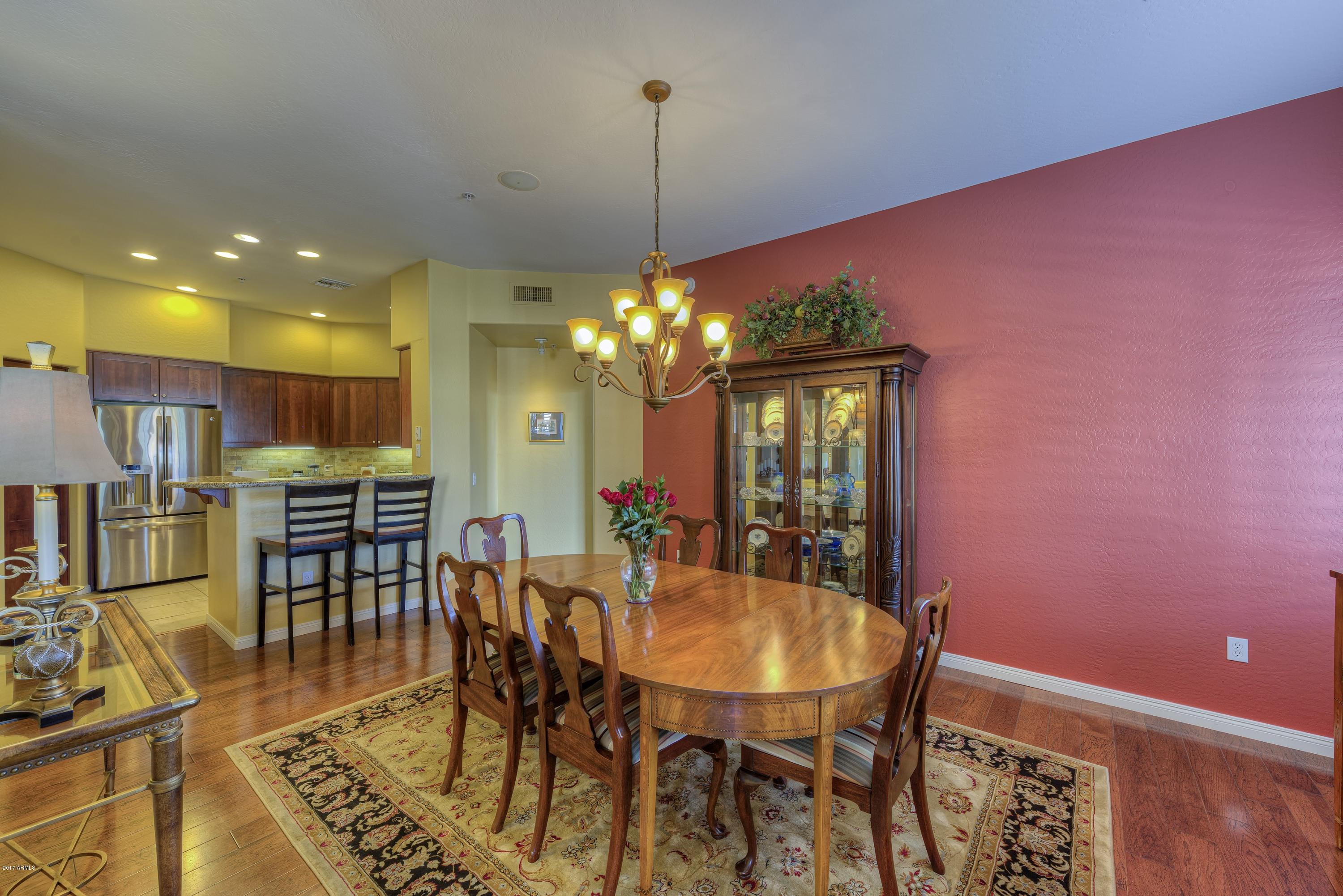 4488 East Thomas Road, Unit 2046 Phoenix, AZ 85018 - Photo 4 of 18 a view of a dining room with furniture and a chandelier