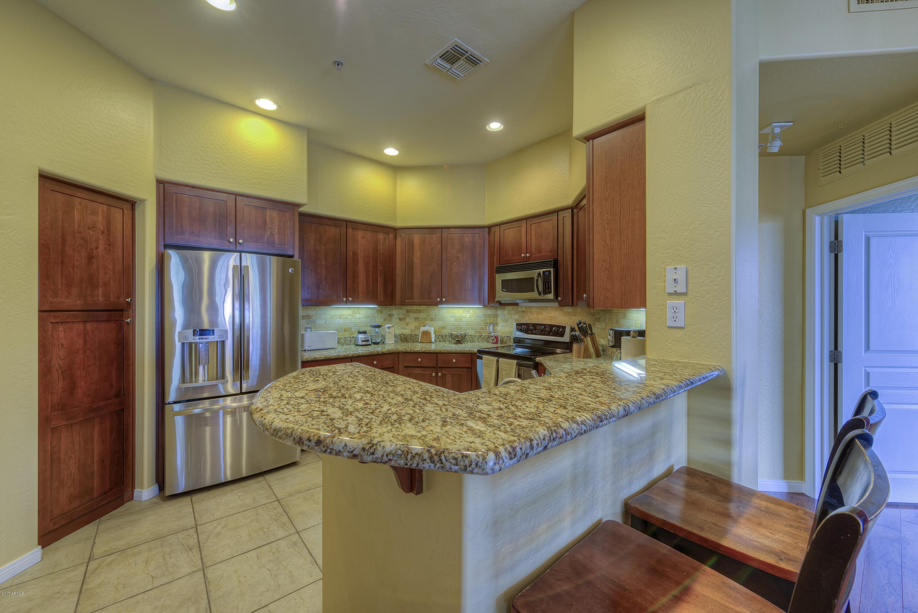4488 East Thomas Road, Unit 2046 Phoenix, AZ 85018 - Photo 5 of 18 a kitchen with stainless steel appliances granite countertop a refrigerator and a sink
