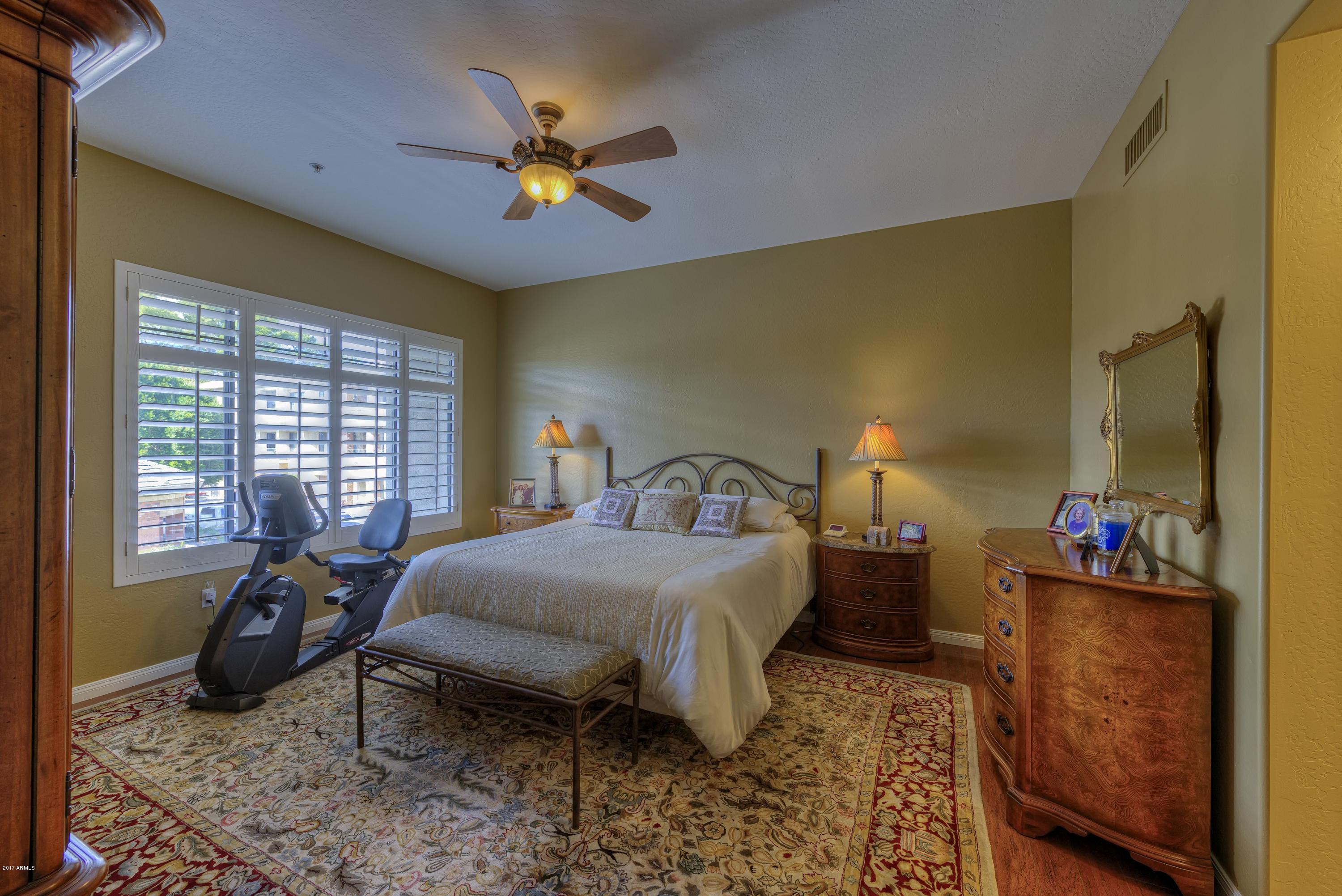 4488 East Thomas Road, Unit 2046 Phoenix, AZ 85018 - Photo 7 of 18 a bedroom with a bed and wooden floor