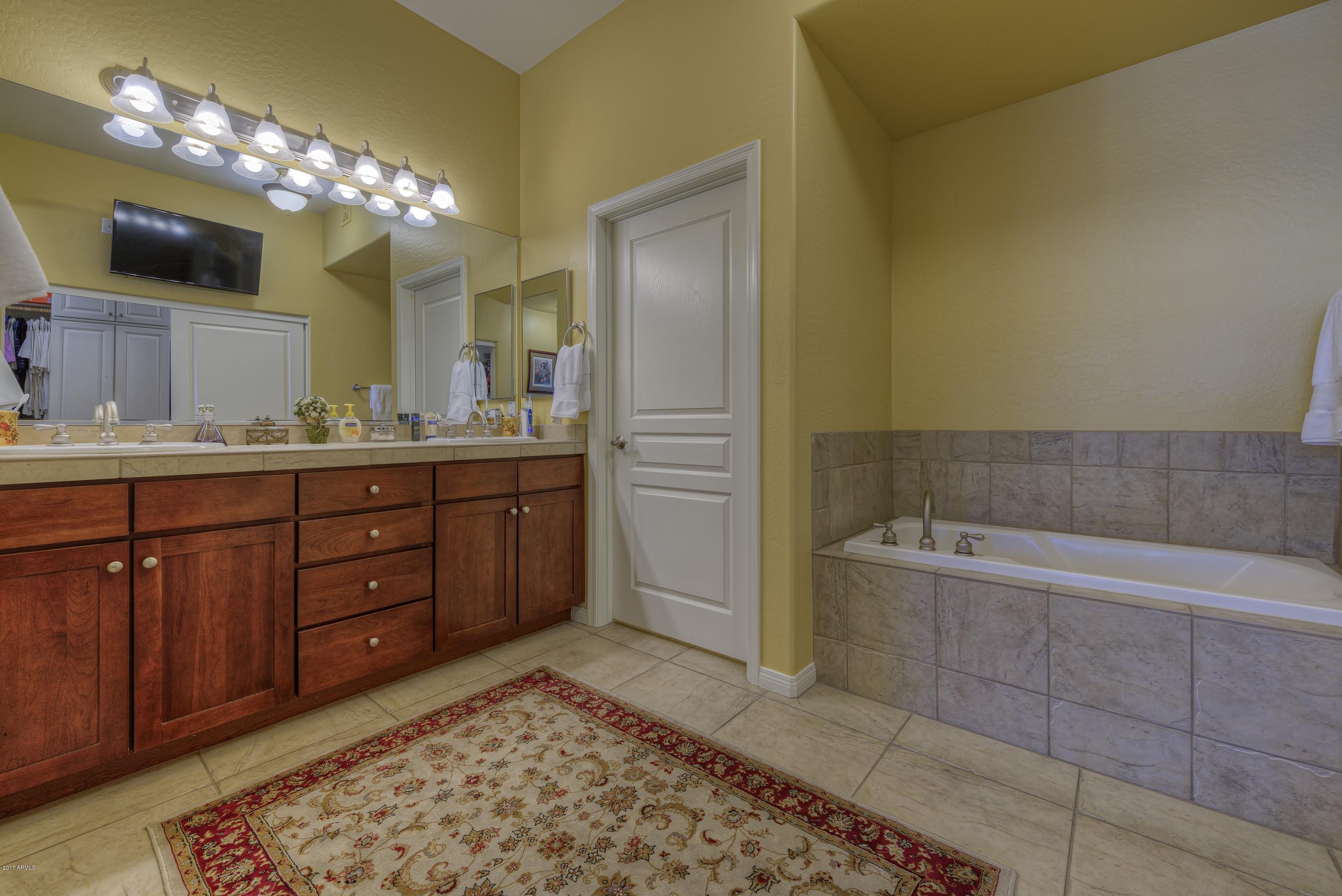 4488 East Thomas Road, Unit 2046 Phoenix, AZ 85018 - Photo 8 of 18 a spacious bathroom with a bathtub sink and a mirror