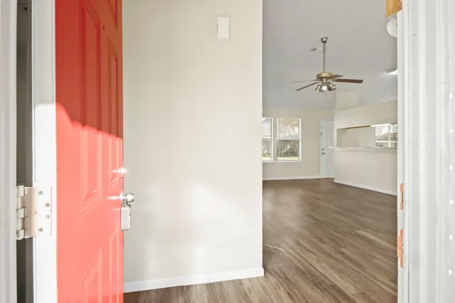 a view of a hallway with wooden floor and cabinet