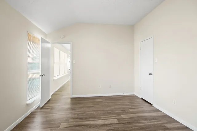 a view of an empty room with wooden floor