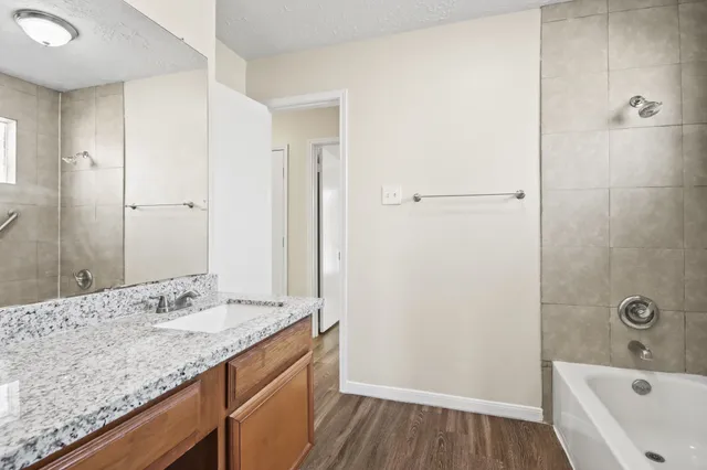 a bathroom with a granite countertop sink a toilet and shower