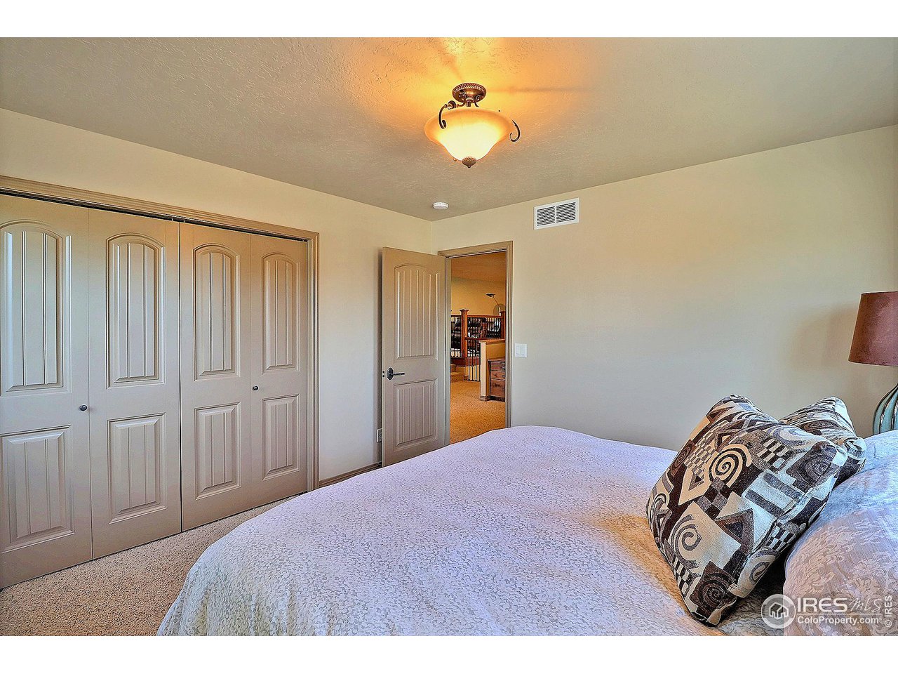 6801 West 34th St Road Greeley, CO 80634 - Photo 28 of 40 a bedroom with a bed and a chandelier