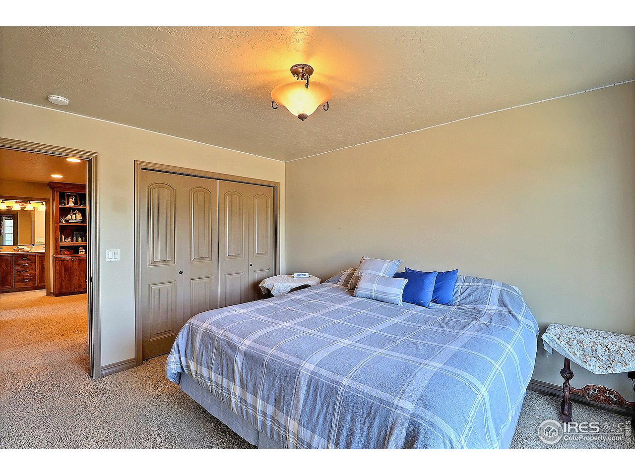 6801 West 34th St Road Greeley, CO 80634 - Photo 29 of 40 a bedroom with a bed and a chandelier