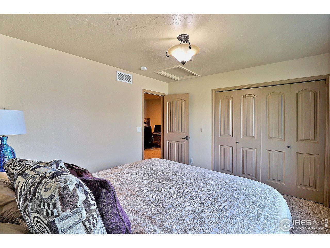6801 West 34th St Road Greeley, CO 80634 - Photo 30 of 40 a bedroom with a bed and a chandelier
