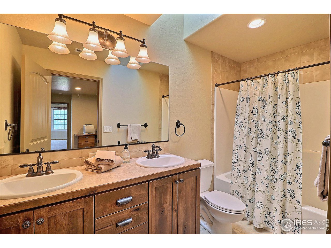 6801 West 34th St Road Greeley, CO 80634 - Photo 31 of 40 a bathroom with a sink a toilet a mirror a vanity and shower