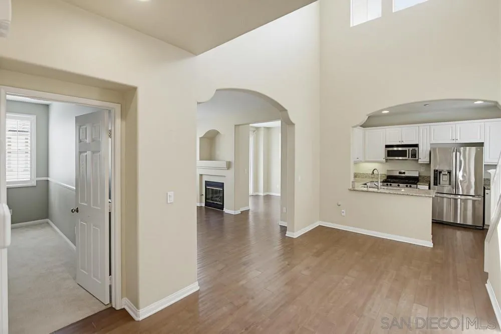 3643 Jetty Point Carlsbad, CA 92010 - Photo 3 of 37 a view of a kitchen with a refrigerator a stove top oven and cabinets