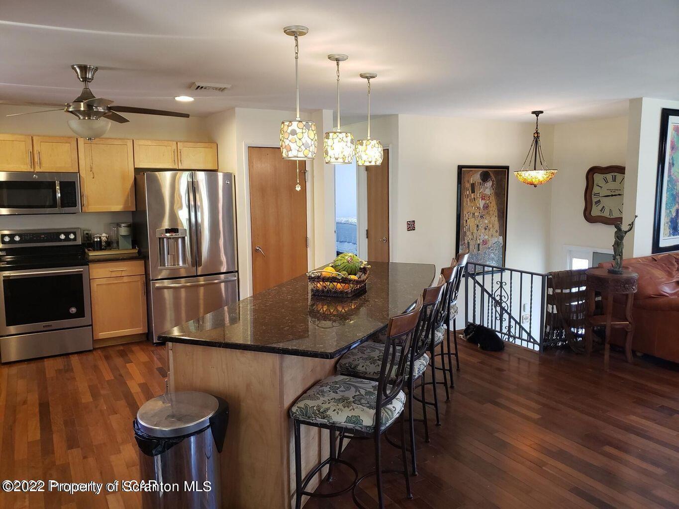 105 Collins Avenue Shavertown, PA 18708 - Photo 11 of 53 a kitchen with stainless steel appliances granite countertop a dining table chairs stove and refrigerator