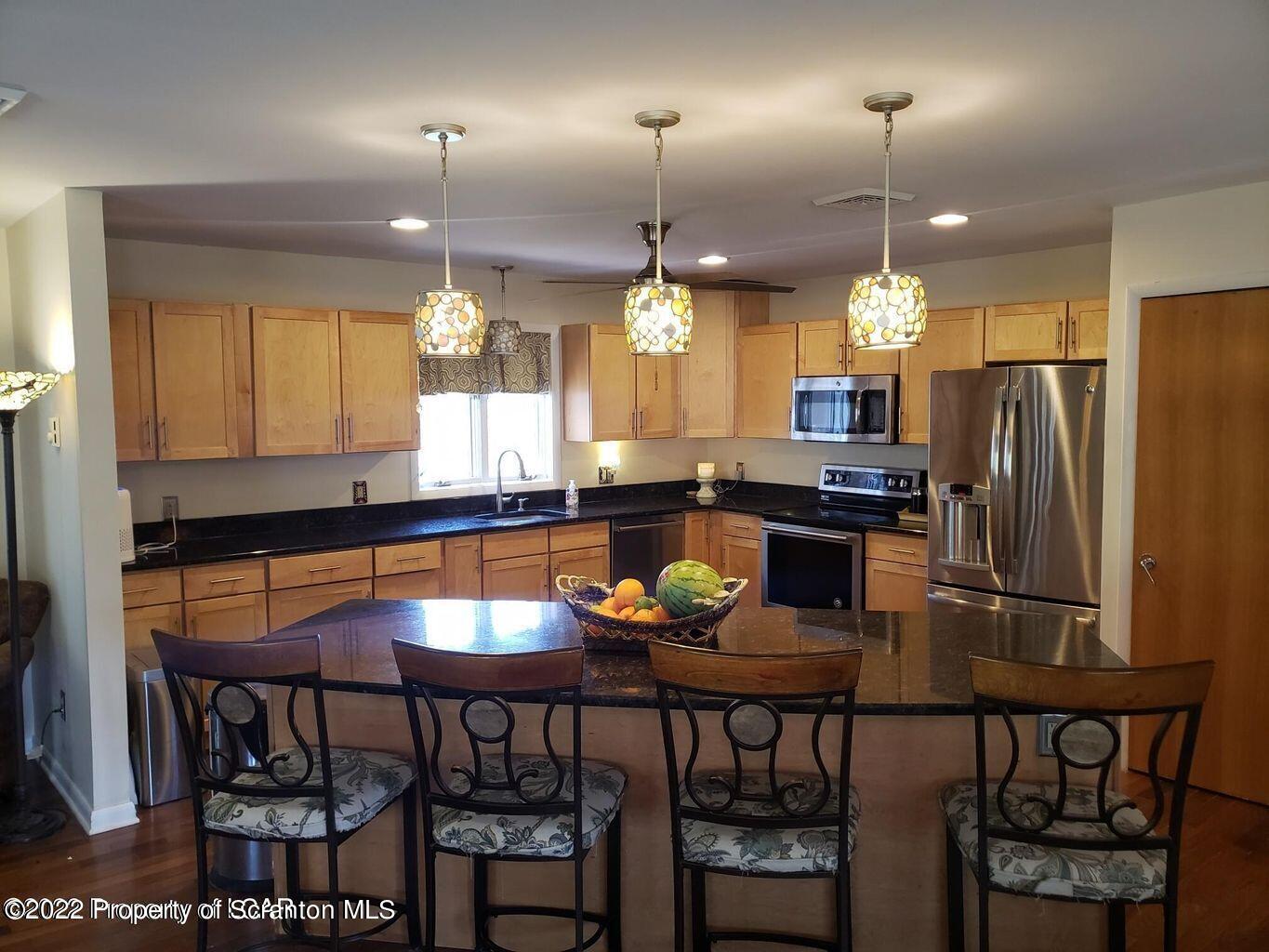 105 Collins Avenue Shavertown, PA 18708 - Photo 12 of 53 a kitchen with stainless steel appliances kitchen island granite countertop a dining table chairs and a refrigerator