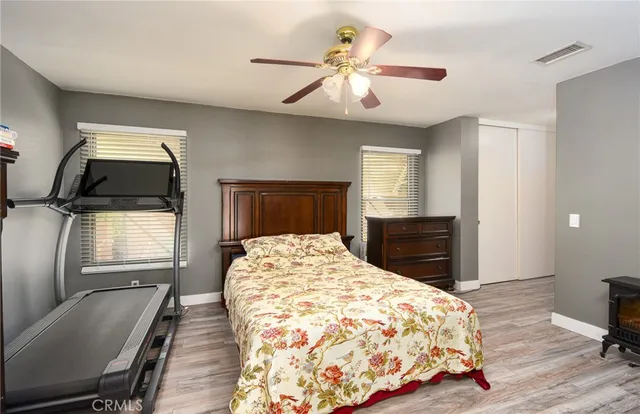 a bedroom with a bed a mirror on dresser and a chandelier