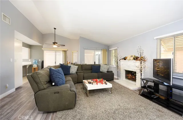 a living room with furniture a fireplace and a flat screen tv