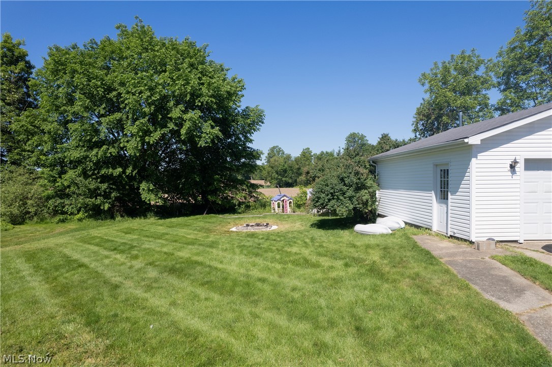3659 Morrow Road Kent, OH 44240 - Photo 35 of 39 Expansive green lawn with mature trees and a built-in fire pit