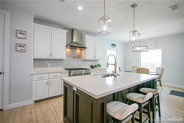 a kitchen with a stove a sink a dining table and chairs