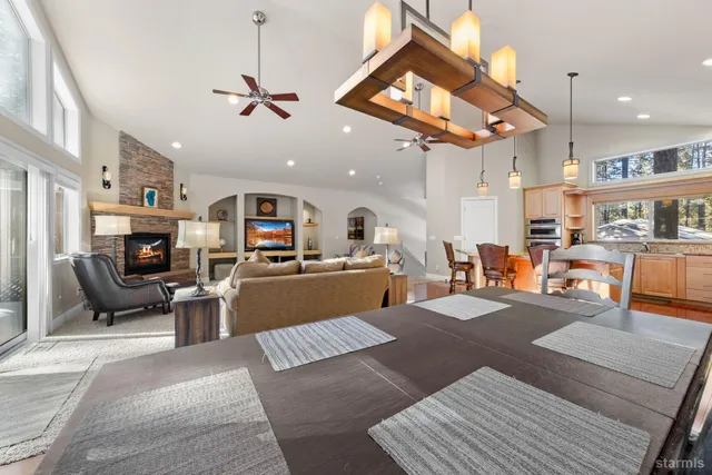 a living room with furniture kitchen view and a chandelier