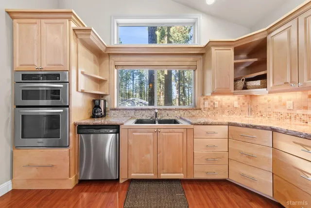 a kitchen with stainless steel appliances a stove a sink and a microwave