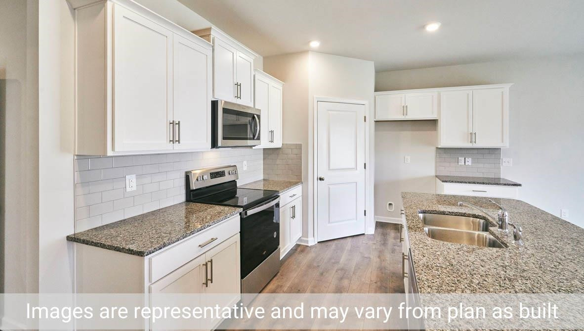 7663 Sand Pit Road Stantonsburg, NC 27883 - Photo 11 of 22 a kitchen with a stove a sink and a microwave