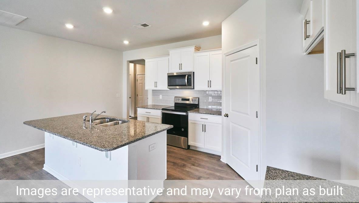 7663 Sand Pit Road Stantonsburg, NC 27883 - Photo 15 of 22 a kitchen with kitchen island granite countertop a stove top oven a sink a counter top space and cabinets